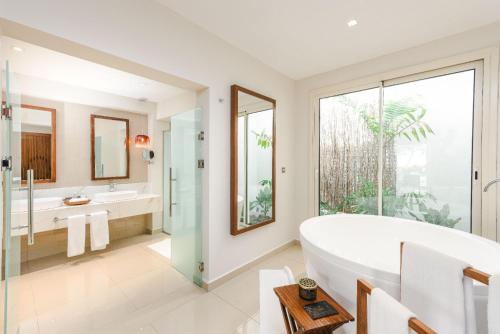 a bathroom with a tub and two sinks and a large window at Diamonds Bijoux in Bwejuu