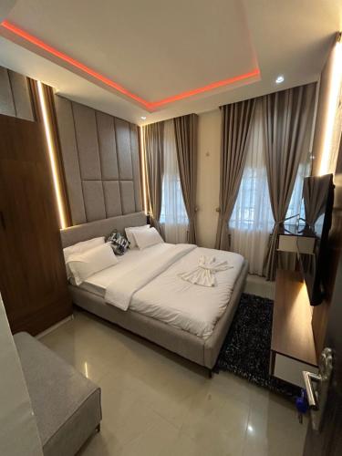 a bedroom with a bed and a television in it at Omas Apartment in Abuja