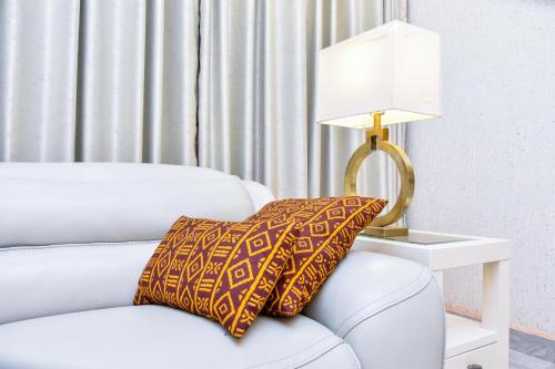 a white couch with a lamp on a side table at THE AFRICAN PALACE- Free Airport Pick up - High Speed Starlink WiFi - Car Rental in Tamale