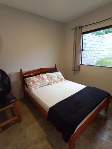 a bedroom with a large bed with a window at Edicula paixão in Muzambinho
