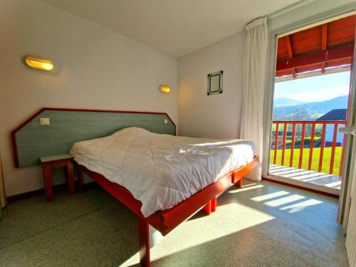 a bedroom with a bed and a large window at B4 Vue Montagnes Piscine in Souraïde