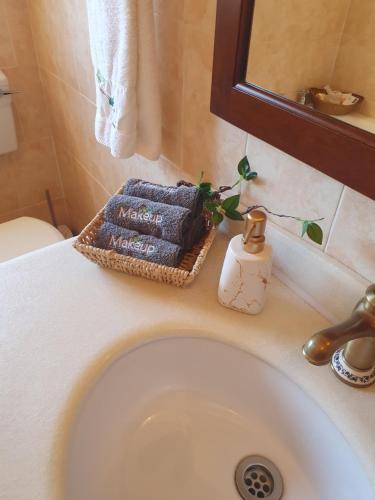 a bathroom sink with a basket of towels and a mirror at Philippolis - Reizigers Rust in Philippolis