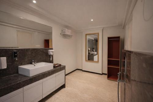 a bathroom with a sink and a mirror at Phoenix Unmatched Comfort - Hotel Near Fateh Sagar Lake Udaipur in Udaipur