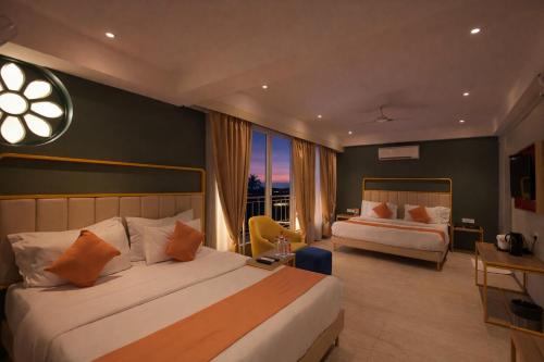 a hotel room with two beds and a large window at Phoenix Unmatched Comfort - Hotel Near Fateh Sagar Lake Udaipur in Udaipur