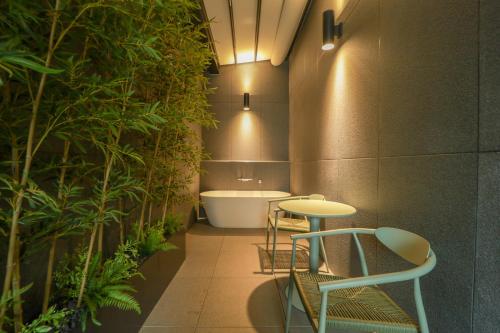 a bathroom with a tub and a table and plants at 잠실 라운지 호텔 in Seoul