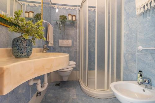 a bathroom with a sink and a shower and a toilet at Hotel Smeraldo in Cesenatico