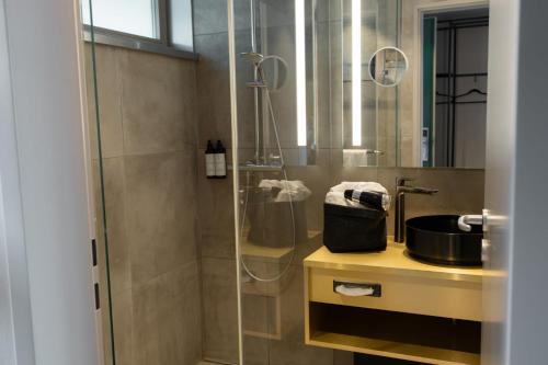 ein Badezimmer mit Dusche und Waschbecken in der Unterkunft Scheck Hotel in München