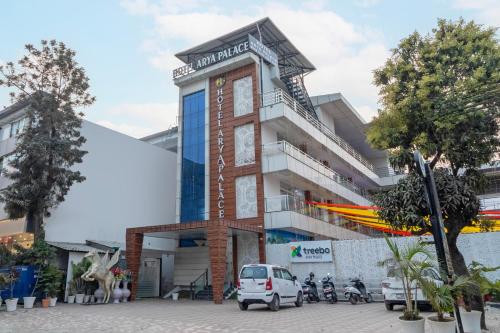 a building with a car parked in front of it at Treebo Arya Palace With Swimming Pool in Dehradun
