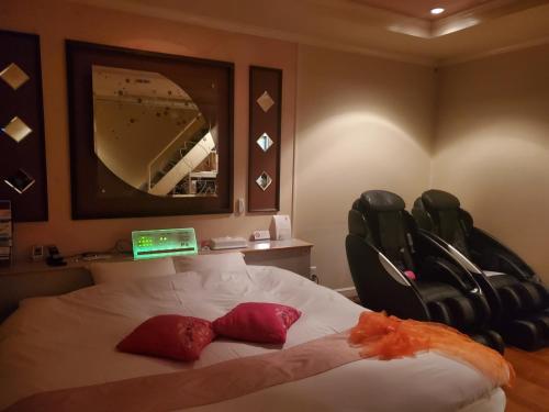 a bedroom with a bed with a mirror and two chairs at RESORT HOTEL Ka (Adult Only) in Chosei
