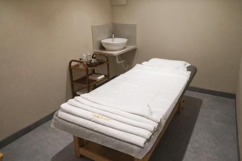 a hospital room with a bed and a sink at Treat Imperial Aurangabad City Center in Aurangabad