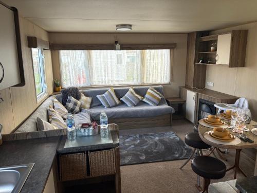 a living room with a couch and a table at TLJ Caravan Hires in Mablethorpe