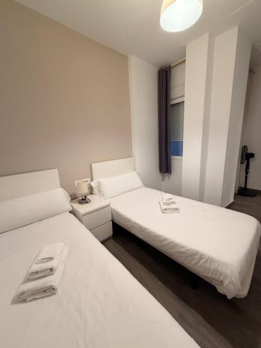two beds in a room with white sheets at Zerka Sendra in Valencia