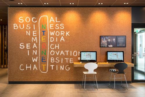 a office with a wall with writing on it at Ibis Muenchen Airport Sued in Hallbergmoos