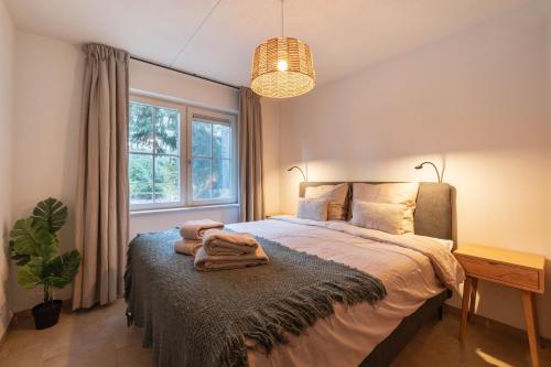a bedroom with a bed with towels on it at Lodge met eigen wellness onder de bomen in Lochem