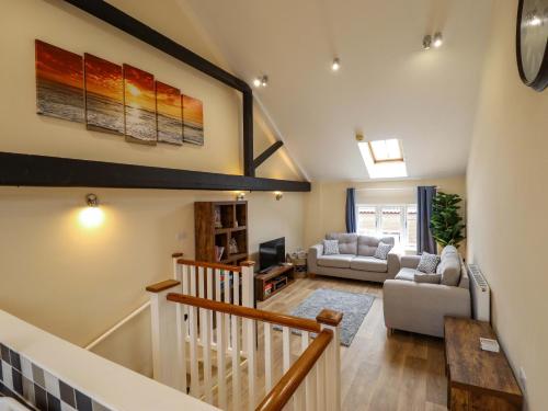 a large living room with a staircase and a living room at 3 The Old Drill Hall in Alford