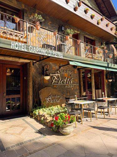 a hotel with tables and chairs in front of a building at Hotel Giardino Di Pietra in Gramado