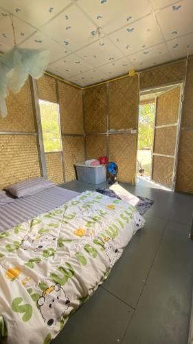 a bedroom with a bed in a room with windows at Poopha home stay in Amphoe Pai