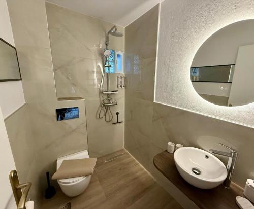 a bathroom with a sink and a toilet and a mirror at NIVAS Apartment Pefkochori in Pefkochori