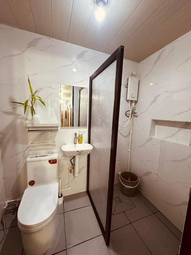 a bathroom with a toilet and a sink at Secret Room Bliss in Baguio