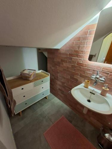 a bathroom with a sink and a brick wall at Villa panorama 1000 in La Chaux-de-Fonds