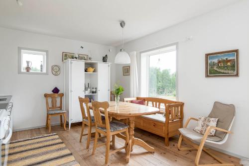 a dining room with a wooden table and chairs at Three Bedroom Cottage Scenic Farm Views Lake Access and Free Boat in Valdemarsvik