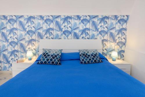 ein Schlafzimmer mit einem blauen Bett und einer blauen Tagesdecke in der Unterkunft To Be Capri in Capri