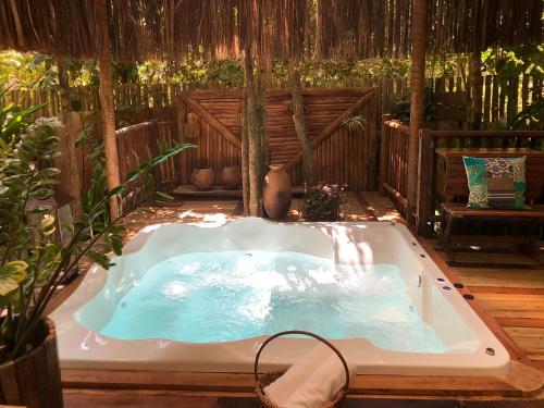 a jacuzzi tub in a garden with at Bangalô Maria, luxo próximo ao mar in Trancoso