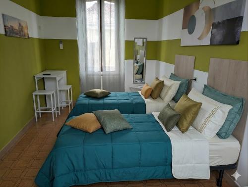 two beds in a room with green walls at Corte Meneghina-short stays in Buscate