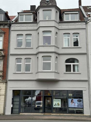 a white building with a clock on top of it at Zentral gelegene Altbauwohnung in Detmold, Paulinchen in Detmold
