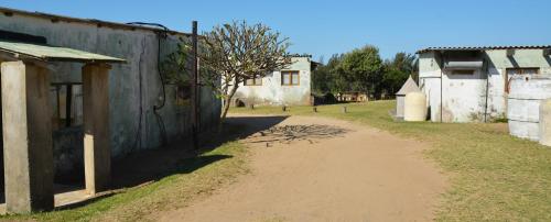 a dirt road in a village with a building at The Prawn Hatchery Pty Ltd on Amatikulu in Dokodweni