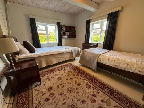 a bedroom with two beds and a rug at Kuliniai by Stirniai lake Moletai district in Kuliniai