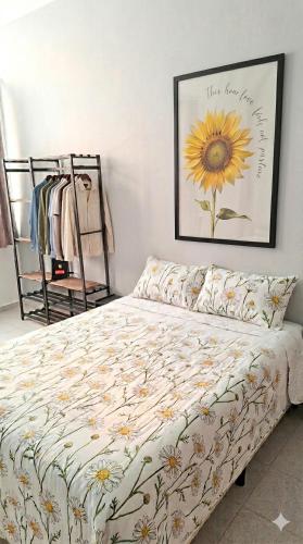 a bedroom with a bed with a sunflower picture on the wall at Studio Catete Flamengo in Rio de Janeiro