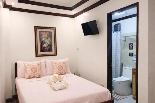 a bedroom with a white bed with a television on the wall at PEPAYEN Homestay in General Luna
