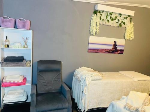 a bedroom with a bed and a chair in it at Crocodile Rock Lodge in Bulawayo