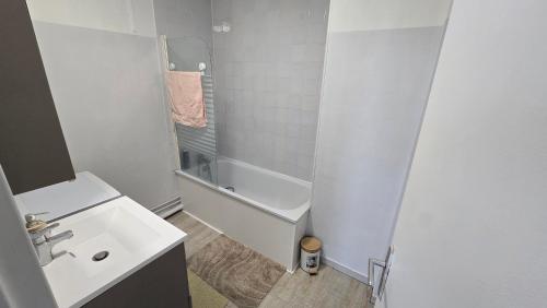 a white bathroom with a sink and a bath tub at Appartement proche Lille in Mons-en-Baroeul