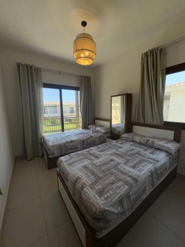 a bedroom with two beds and a chandelier at Marassi villa in El Alamein