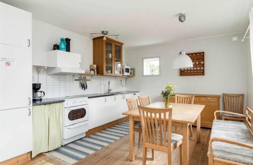 a kitchen and dining room with a table and chairs at Three Bedroom Farm Cottage Lake Access and Free Boat in Valdemarsvik