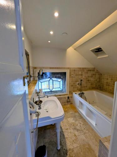 a bathroom with a sink and a bath tub at Boutique Hotel Westerlee in Westerlee