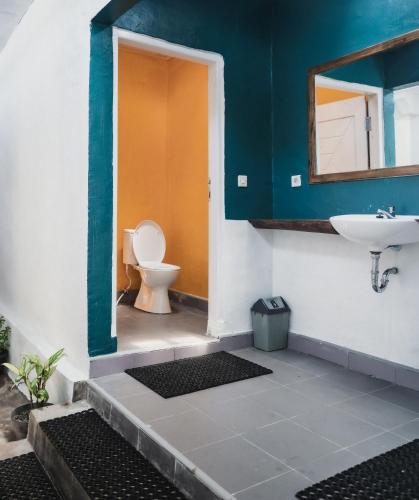 a bathroom with a toilet and a sink at Comuna Tigabelas in Gisi