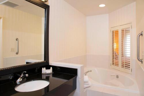 a bathroom with a tub and a sink and a mirror at Fairfield Inn & Suites by Marriott Omaha Downtown in Omaha