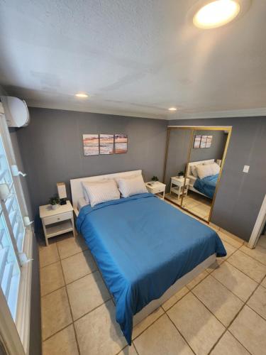 a bedroom with a blue bed and a mirror at Ola Azul Apartment in Punta Santiago