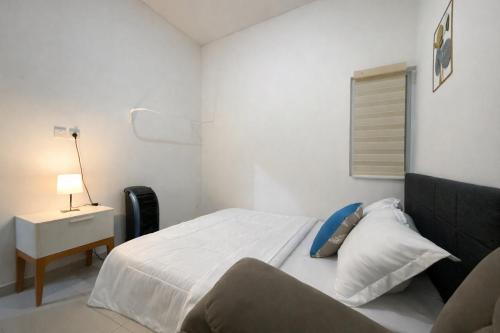 a bedroom with a bed and a desk with a lamp at Alayam Villa Padalarang near whoosh, wahoo waterworld & ikea in Padalarang