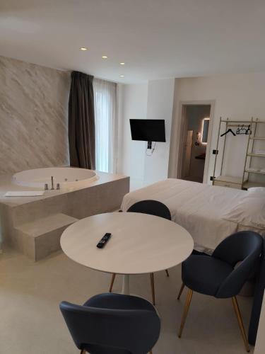 a hotel room with a bed and a tub and chairs at Gabbiano Suites in Cervia