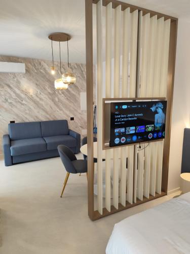 a living room with a couch and a tv on a wall at Gabbiano Suites in Cervia