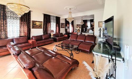 a living room with leather couches and a television at Silver Coast Pool & Resort Villas in Arnal