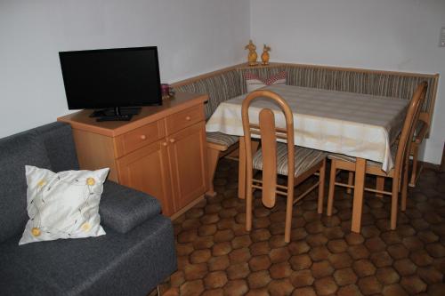a living room with a table and a tv and a couch at Schröckerhof in Mariapfarr