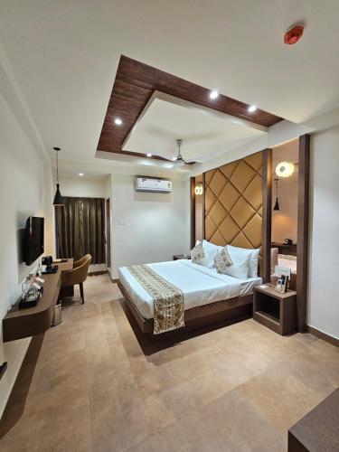 a bedroom with a bed and a desk and a couch at Hotel Camel managed by CLAY in Mundra