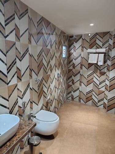 a bathroom with a toilet and a sink at Hotel Camel managed by CLAY in Mundra