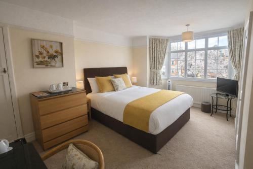 a bedroom with a large bed and a window at Hampton Lodge En-Suite Rooms with Free Parking in Stratford-upon-Avon