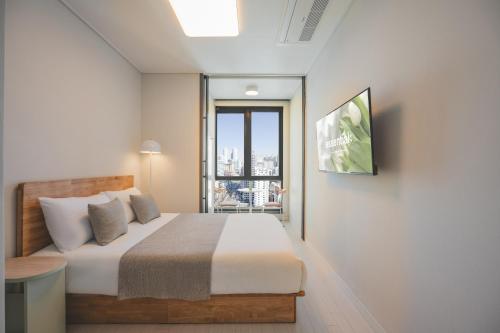 a bedroom with a bed and a large window at Gem Stay Seomyeon in Busan